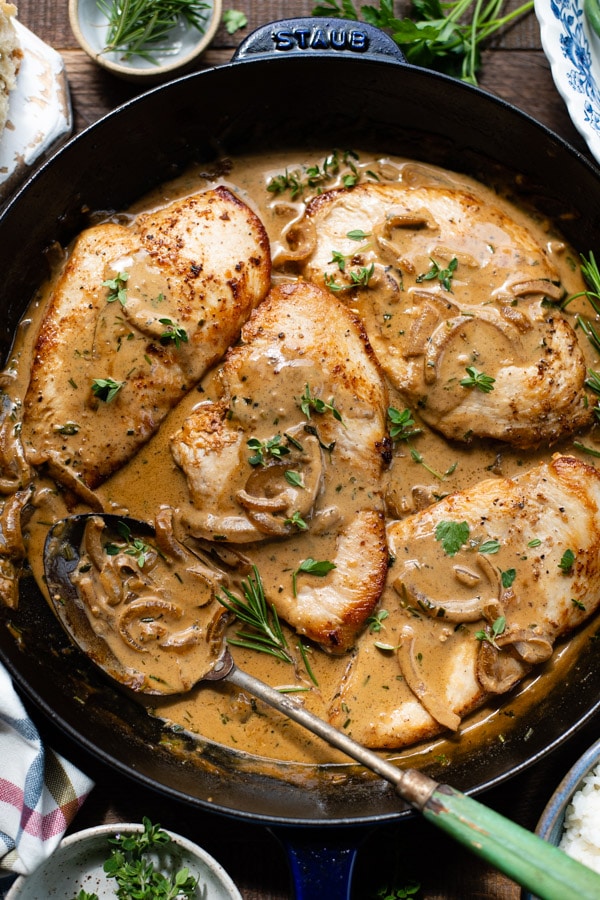 Close overhead image of chicken breast with Dijon mustard sauce in a cast iron skillet