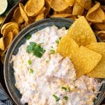 Bowl of creamy corn dip with tortilla chips on the side