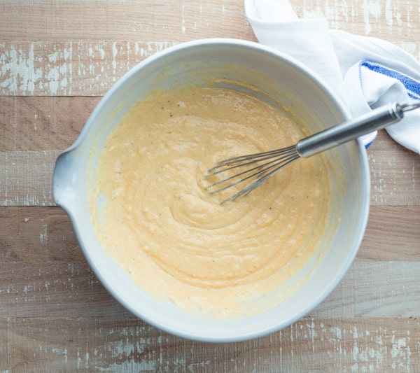 Cornbread batter in a mixing bowl with whisk