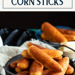 Side shot of cornbread sticks on a serving tray with text title box at top