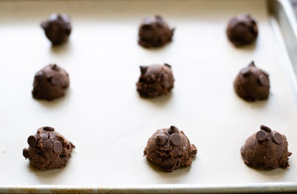 Double chocolate chip cookie dough rounds on a baking sheet