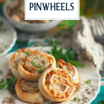 Plate of baked Italian pinwheels with text title overlay
