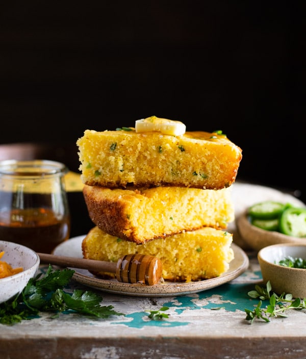 Stack of jalapeno cheddar cornbread slices on a plate