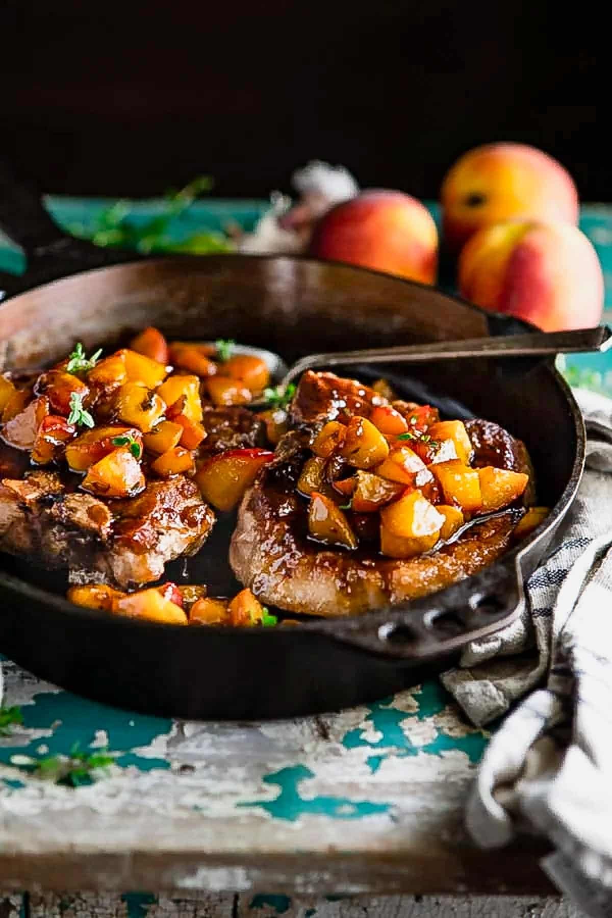 Peach sauce for pork chops in a cast iron skillet.