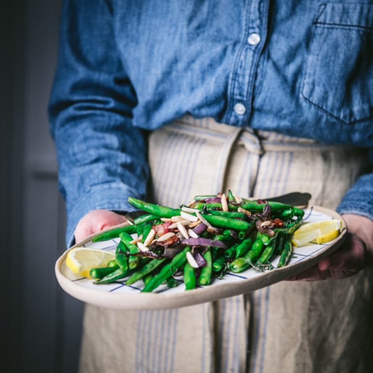Square featured image of cook holding a platter of roasted green beans
