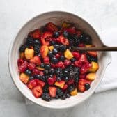 Stirring together easy fruit salad with vanilla pudding.