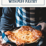 Hands holding a skillet of chicken pie with puff pastry and text title box at top