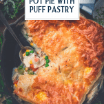 Overhead shot of a spoon in a pan of chicken pot pie with puff pastry and text title overlay