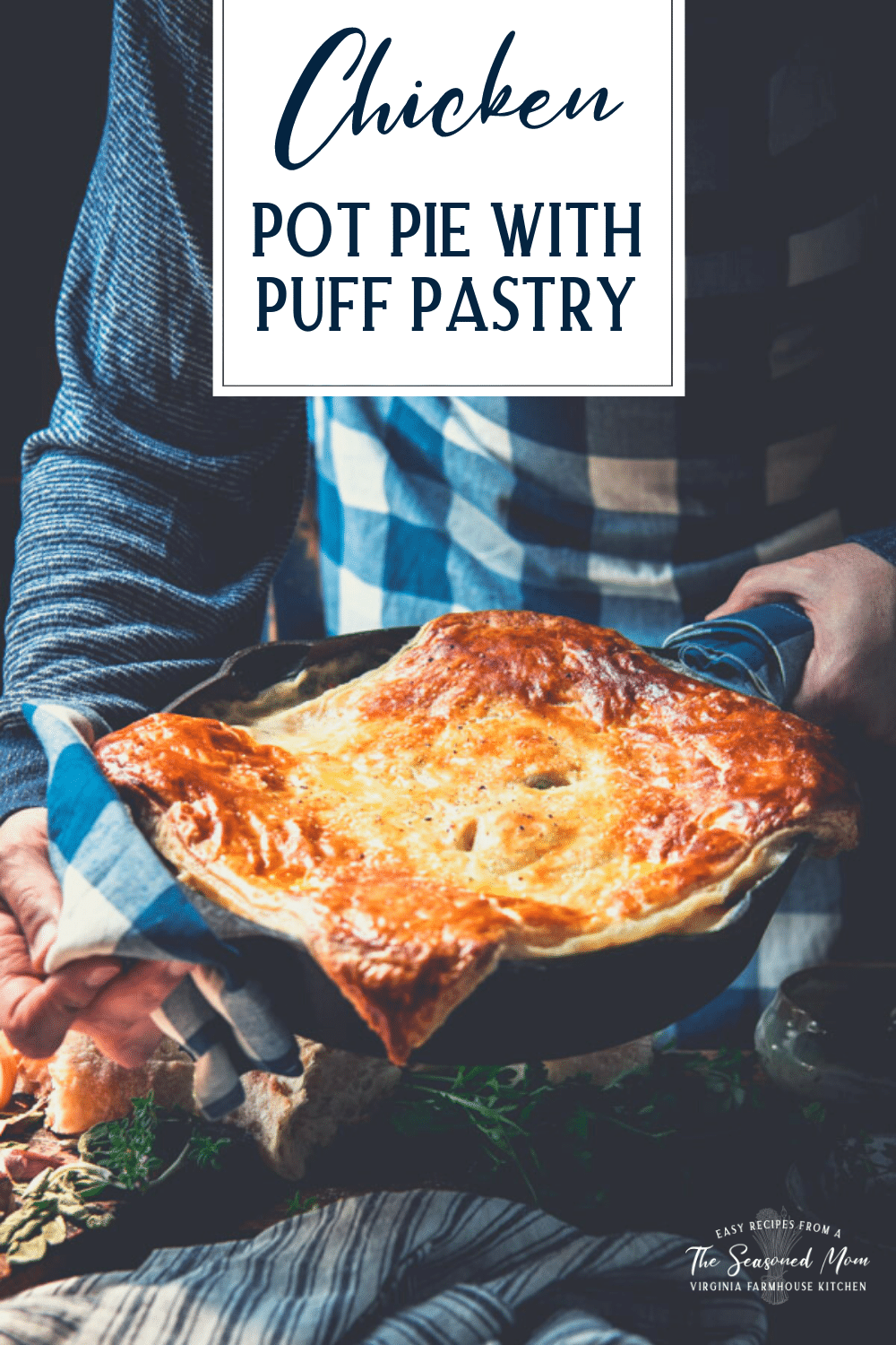 Hands holding a pan of chicken pot pie with puff pastry and text title overlay