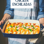 Hands holding a pan of the best chicken enchilada recipe with text title overlay