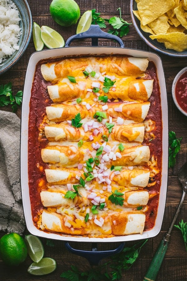 The best chicken enchilada recipe in a blue baking dish on a wooden table
