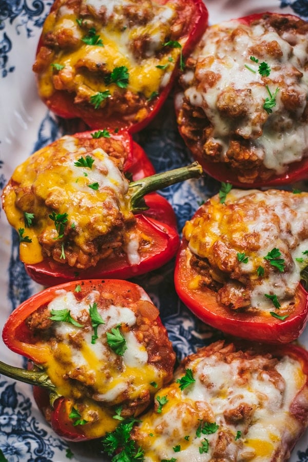 Close overhead image of healthy stuffed peppers with ground turkey on a blue and white tray.