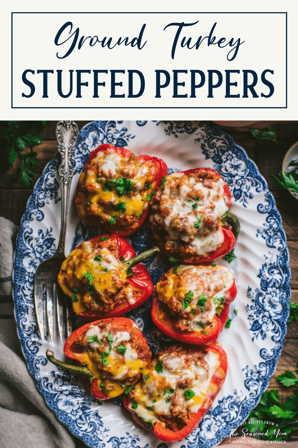 Tray of ground turkey stuffed peppers on a wooden table with text title box at top