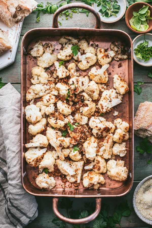 Overhead shot of a copper roasting pan full of cauliflower with parmesan bread crumbs
