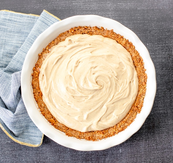 A creamy old fashioned peanut butter pie with a vanilla wafer cookie crust, served in a white ceramic pie dish.