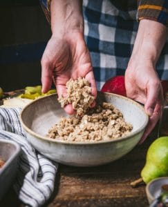 Oat streusel topping in a large white mixing bowl