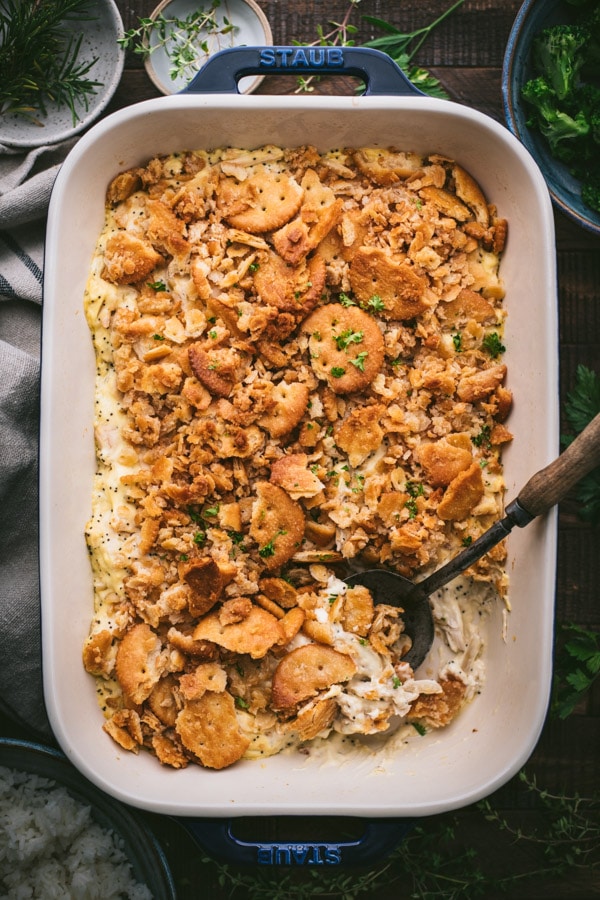 Overhead shot of an easy poppy seed chicken casserole with almonds on a wooden table