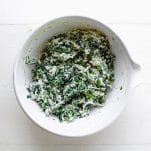 Spinach and ricotta mixture in a white mixing bowl