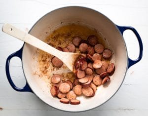 Browning andouille sausage in a pot