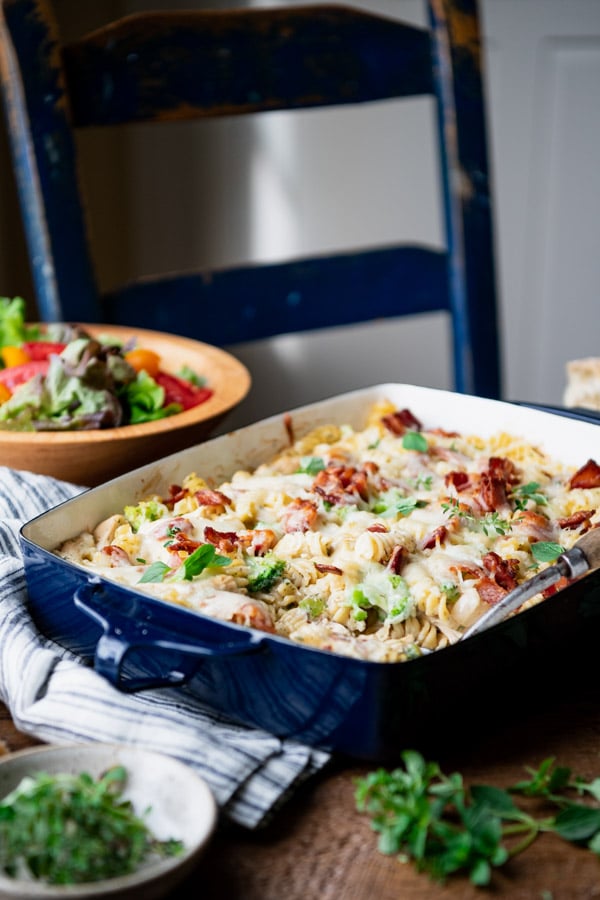 Side shot of a chicken bacon ranch casserole recipe in a blue dish on a dinner table