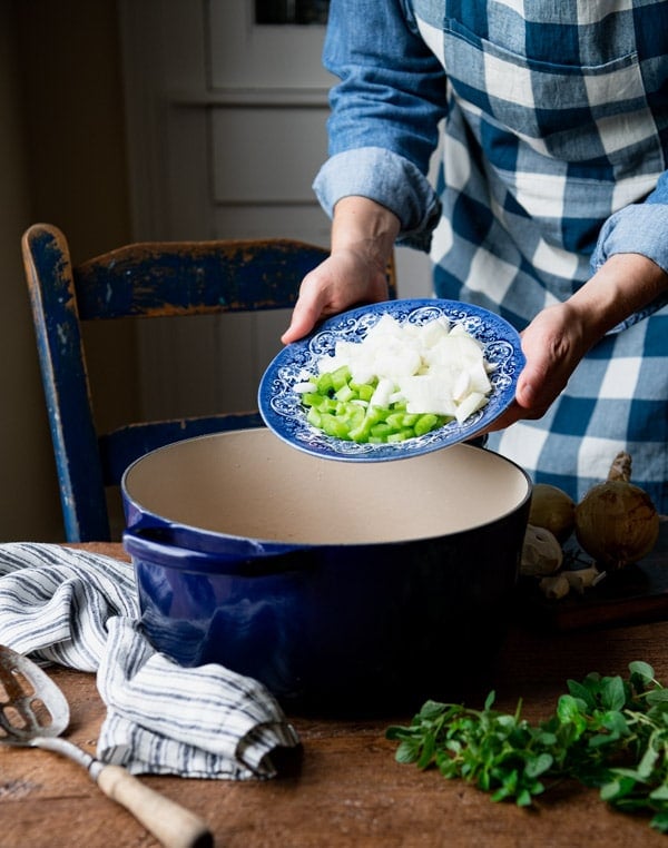 Adding diced vegetables to a Dutch oven