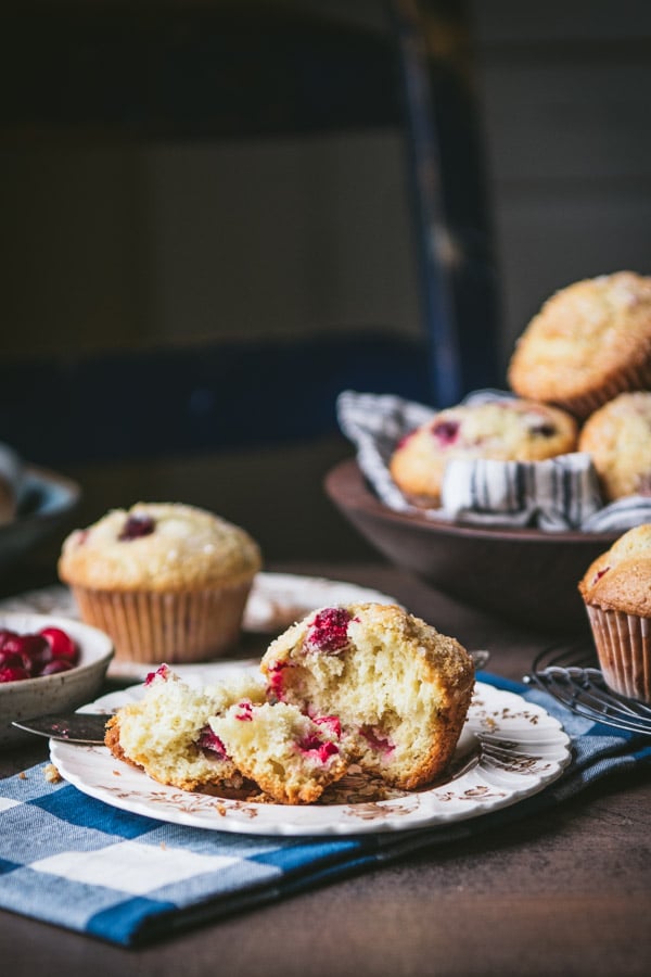 Homemade fresh cranberry muffin on a plate with a bite taken out.