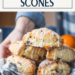 Hands serving a tray of Starbucks cranberry orange scones with text title box at top