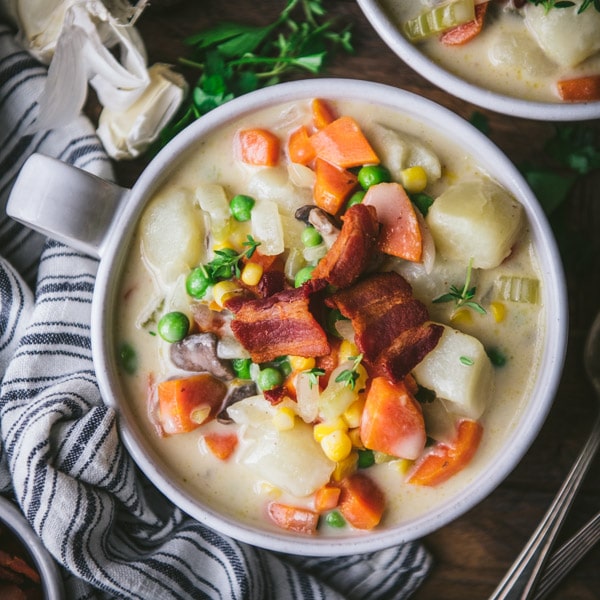 Overhead image of a bowl of the best creamy vegetable soup recipe topped with bacon