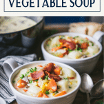 Creamy vegetable soup in white bowls on a table with text title box at top