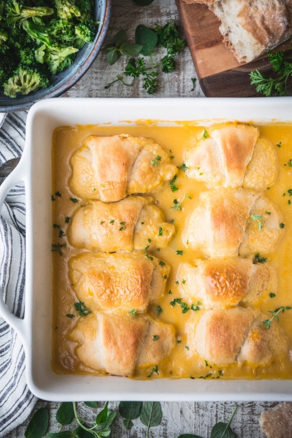 Close overhead image of a pan of crescent roll chicken casserole on a white wooden table