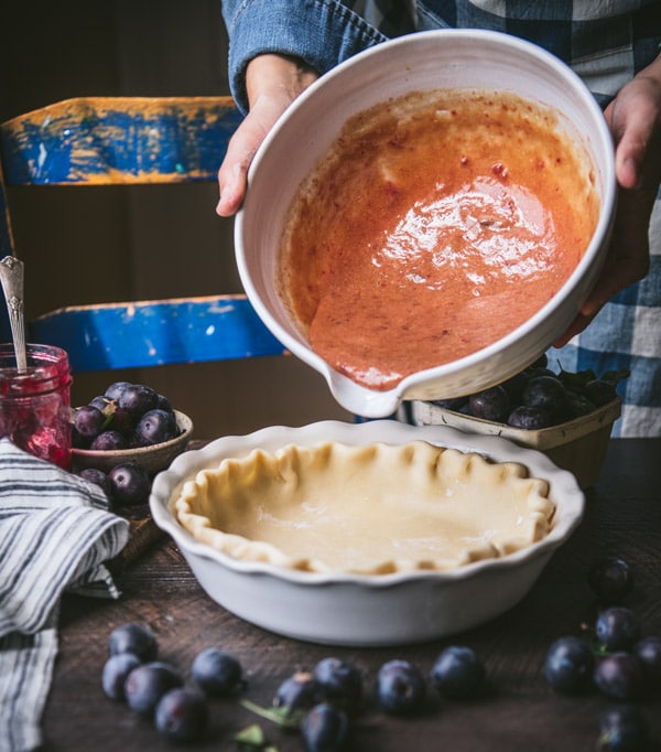 Process shot showing how to make damson plum pie.
