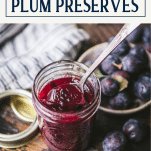 Spoon in a jar of damson plum preserves with text title box at top