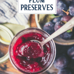 Spoon in a jar of damson plum preserves with text title overlay