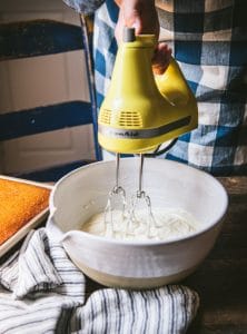 Electric mixer making cream cheese frosting.