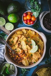 Overhead shot of taco casserole with tortilla chips on a blue table