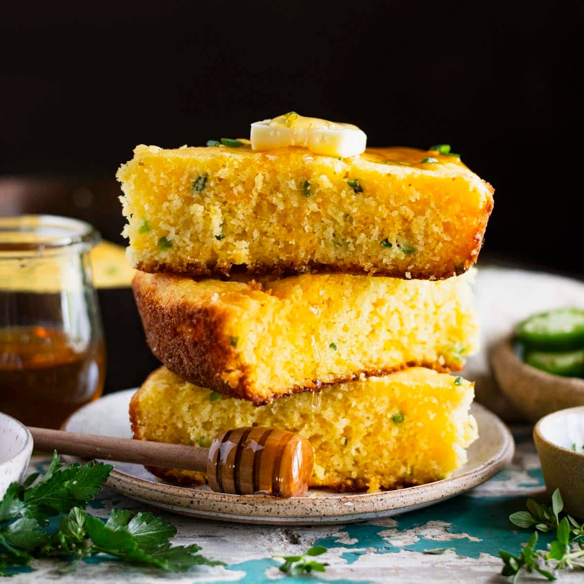 Square side shot of a plate of slices of jalapeno cheddar cornbread.