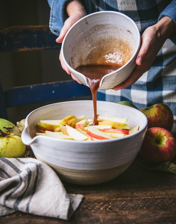 Pouring brown sugar and butter mixture over apples