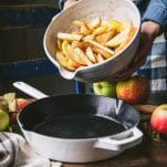 Adding apple slices to a cast iron skillet