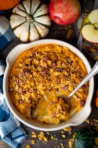 Overhead shot of a dish of mashed butternut squash casserole on a wooden table