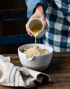 Pouring melted butter over a bowl of stuffing mix