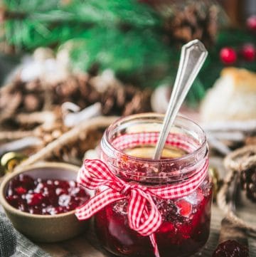 Jar of Christmas jam on a cutting board with biscuits