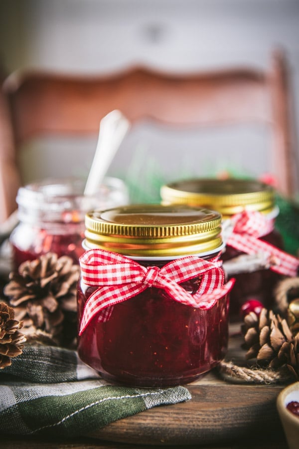 Side shot of jars of Christmas jam decorated with red and white ribbon