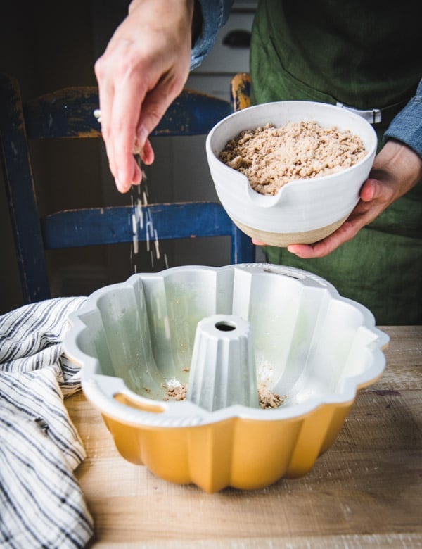 Sprinkling streusel in a bundt pan