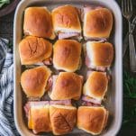 Overhead shot of ham and cheese sliders with brown sugar in a baking dish