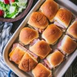 Close overhead shot of a pan of easy ham and cheese sliders on hawaiian rolls in a baking dish