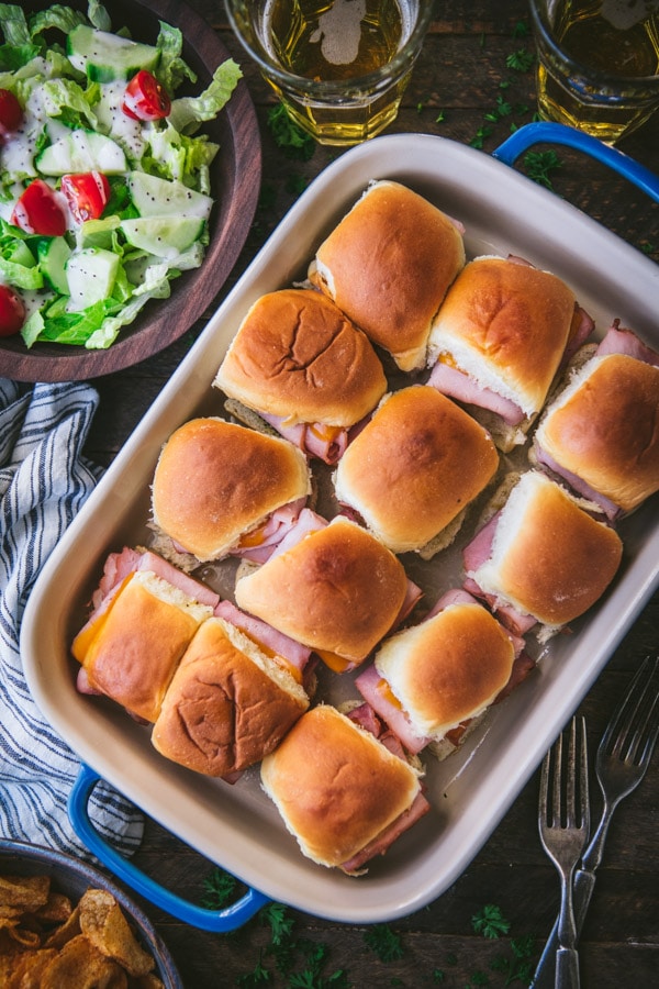 Overhead image of hawaiian roll ham and cheese sliders served with a salad