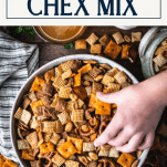 Hand reaching into a bowl of homemade Chex mix with text title box at top