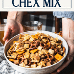 Hands serving a big bowl of homemade Chex mix recipe with text title box at top