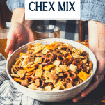 Hands holding a bowl of homemade chex mix with text title overlay