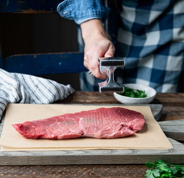Process shot showing how to tenderize steak